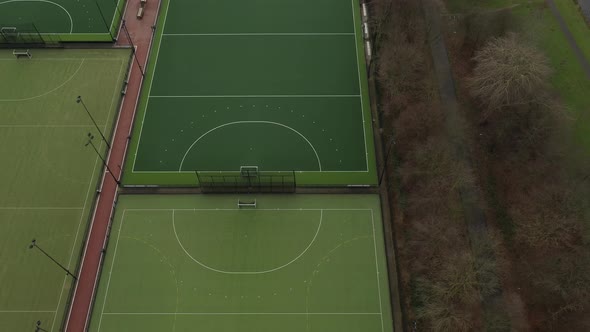 Aerial view looking over multiple green sport fields with next to an recreational nature area