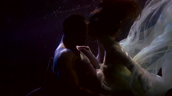 Tender Caress of Young Lovers Underwater, Black Man and White Woman Are Floating Together