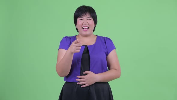 Happy Young Overweight Asian Woman Laughing and Pointing at Camera