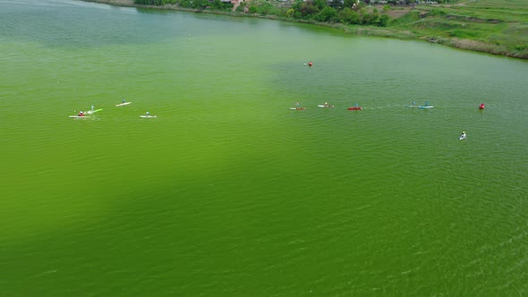 Aerial View of Young Athletes Exercising on Rowing Boats on the Lake on a Summer Day