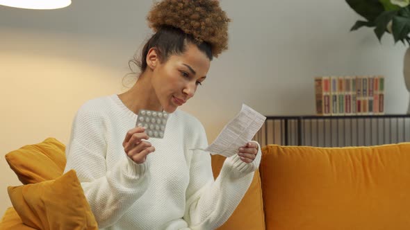 Beautiful Black Woman Reads the Medical Instructions for Pills