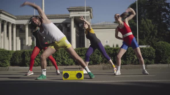 Wide Shot of Dancing Sport in 1980s Outdoors. Positive Fit Caucasian Man and Women Training To Disco