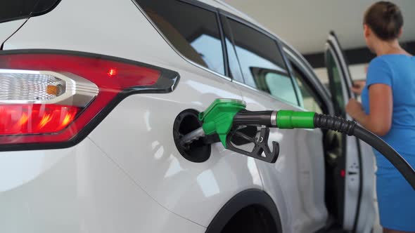 Woman Waiting for Her Car To Refuel at a Gas Station