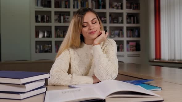 Portrait of a Thoughtful Girl Student in the Library with Books