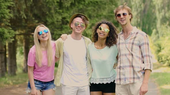 Two Young Couples Posing Embraced for Camera, Enjoying Summer Outdoor Activities