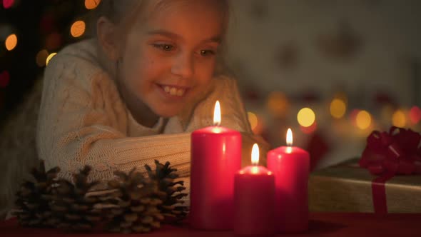 Little Beautiful Girl Looking at Burning Candles, Waiting for X-Mas Celebration