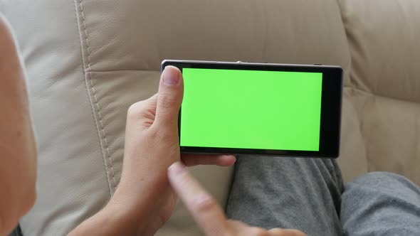 Female holds  green screen display  smart phone in hands 4K 2160p 30fps UHD footage - Woman scrollin