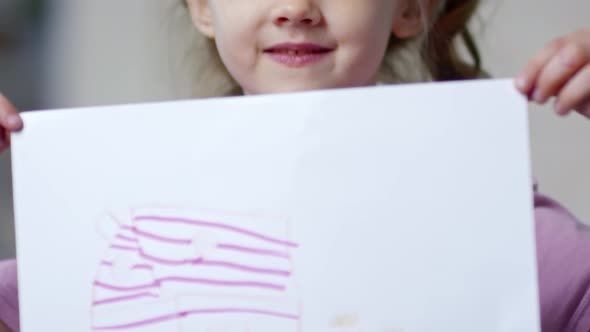 Adorable Girl Holding Picture and Smiling