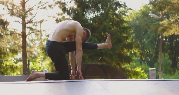 Young Man Practicing Yoga Outdoors