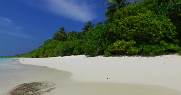 Daytime above island view of a white paradise beach and blue ocean background in colourful