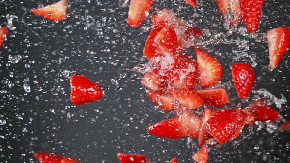 Super Slow Motion Shot of Fresh Strawberries and Water Side Collision on Grey Background at 1000Fps.