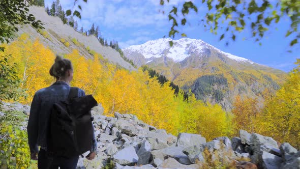 young tourist walks through mountainous area and looks at beautiful landscape.