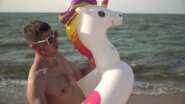 Cheerful Funny Crazy Man in an Inflatable Swimming Ring on the Sea Beach