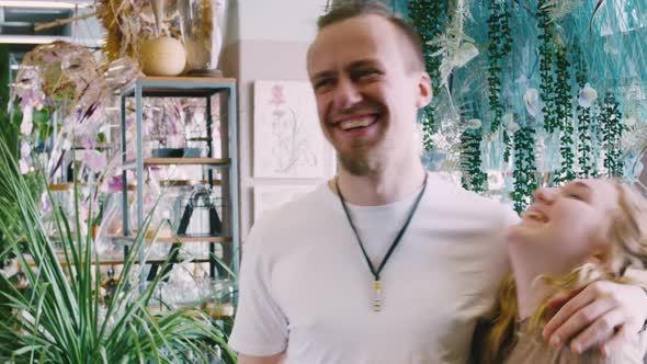 A Husband and His Wife Kiss in a Greenhouse Among the Greenery