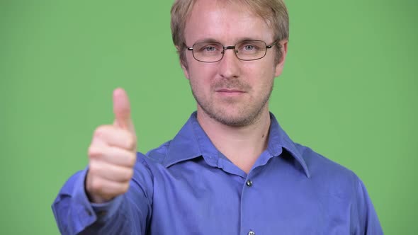 Head Shot of Happy Handsome Blonde Businessman Giving Thumbs Up