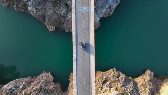 A car passes through a bridge over a river aerial view 4 K