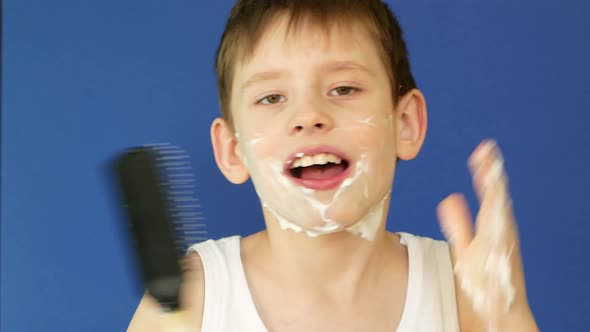 Portrait of a cheerful caucasian boy 7 years old in the bathroom singing a comb into the microphone