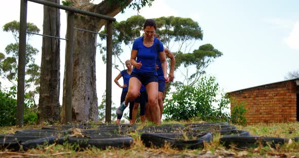 Fit people practicing tire obstacle course training 4k
