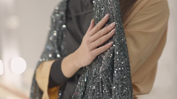 Closeup Female Hand Touching Sparkling New Dress Indoors