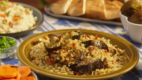 Sprinkling Greenery on Bulgur with Eggplant Closeup Couscous with Meat on Background