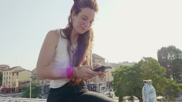 Slow motion shot of young woman using smartphone in city