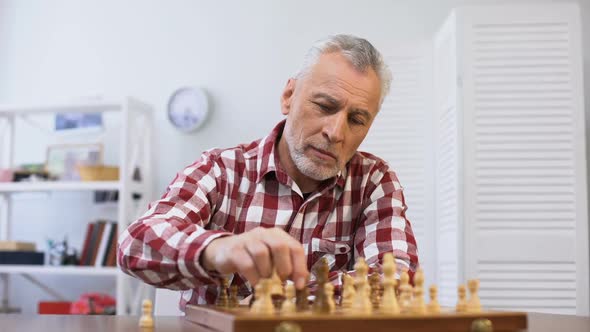 Aging Pensive Male Playing Chess Alone