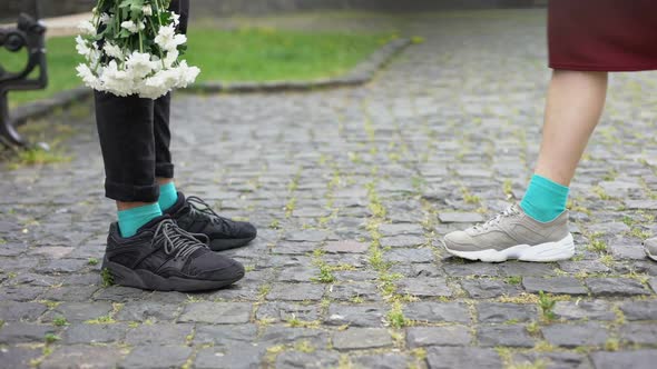 Legs of Teens, Girlfriend Coming to Boyfriend With Flowers, Standing on Tiptoes