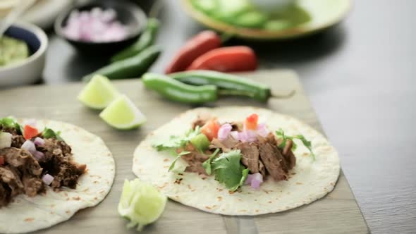 Pulled pork carnitas with pico de gallo on a flour tortilla.