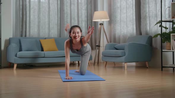 Young Asian Trainer Female In Sports Clothes Speaking And Doing Yoga In Balancing Table Pose