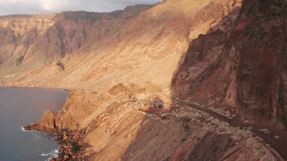 Aerial dolly pan left, view on caldera Las Playas from  ocean at dawn