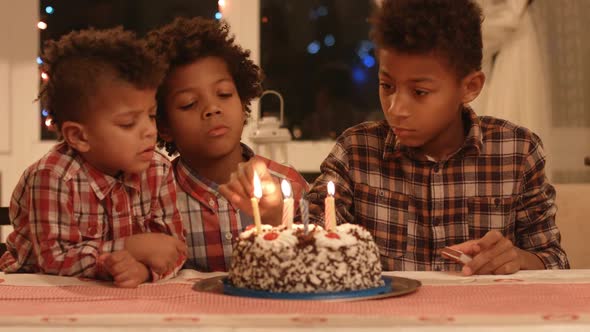 Kids Lighting Birthday Cake's Candles.