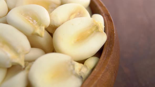 Dry maize mote in rustic wooden bowl close up. Macro shot. Hominy grain