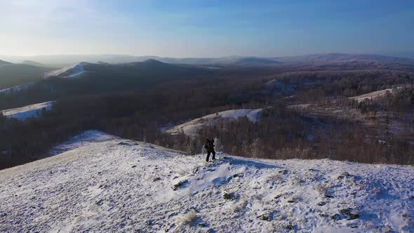 Lonely Hiker Walks Along the Top of a Mountain Range