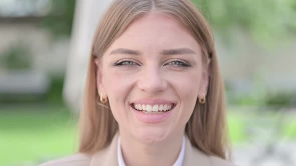 Close Up of Face of Happy Young Businesswoman Smiling at Camera