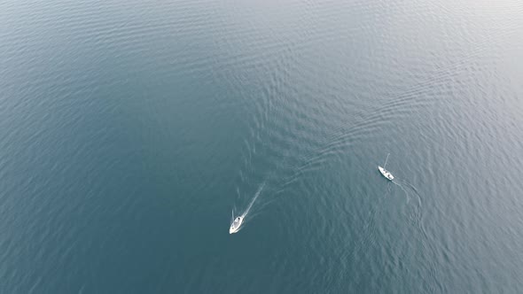 Two boats on a blue lake turning around each other on the quiet water surface. Perfect for introduct