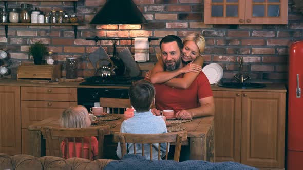 Dad Mom and Two Children Gathered in the Kitchen at the Dinner Table for Dinner