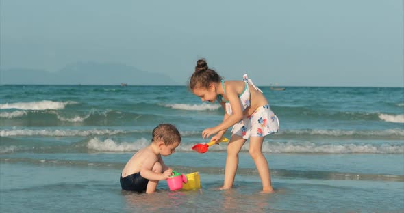 Happy and Carefree Children Playing By the Sea with Sand . Children Playing, Brother and Sister Play