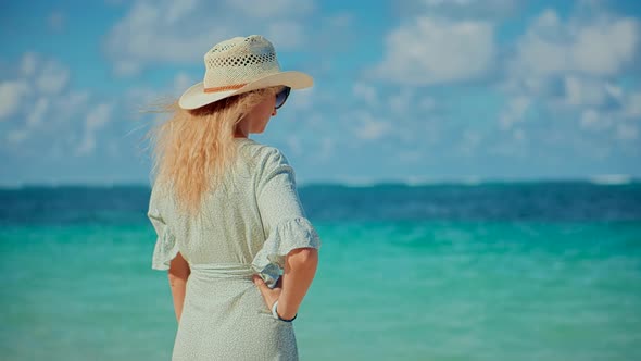 Woman Relaxing On Bahamas Flowing Dress Blowing In Wind. Travel Mood Wind Blows Dress On Ocean.