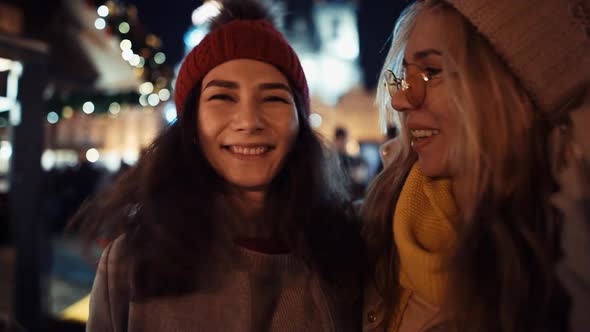 Two Young Woman Girlfriends Lesbian Kissing and Laughing with Sparklers in the Street on Christmas