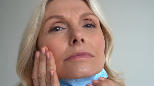 Worried 50s Middle Aged Woman Touching Irritated Face Skin After Face Mask