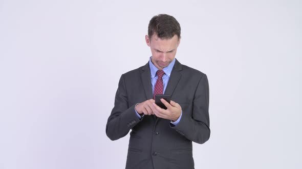 Studio Shot of Happy Businessman Using Phone and Getting Good News