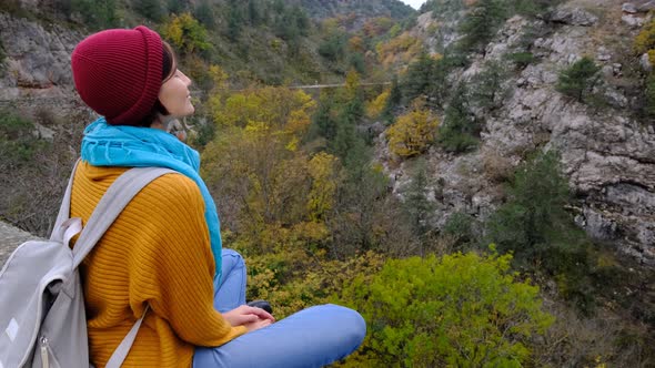 Pretty Smiling Asian Woman with Backpack Sitting