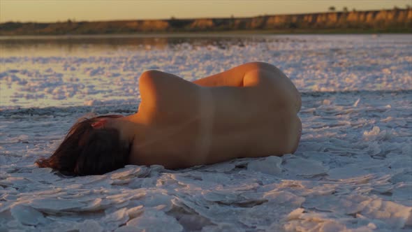 Attractive Soulful Nude Emotive Caucasian Female at a Salt Lake in Slow Motion