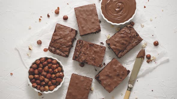 Fresh Homemade Chocolate Brownie Served with Hazelnuts and Melted Cream