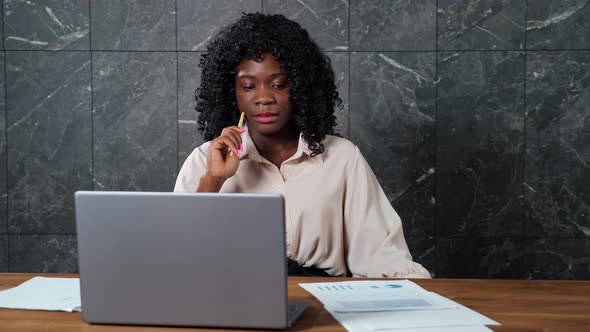 Thoughtful Black Businesswoman Looks Around Holding Pen