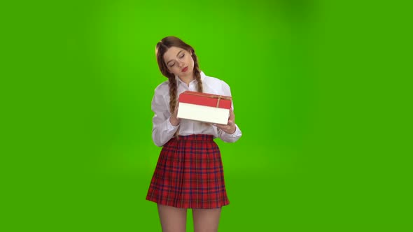 Girl Holds a Gift in Her Hands and Is Pleased. Green Screen