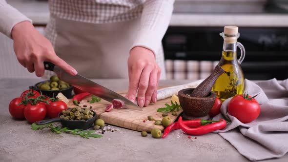 Woman Slicing Fuet Sausage with Knife at Domestic Kitchen