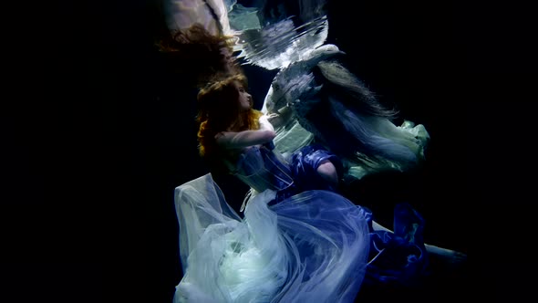 A Young Girl Underwater in the Contrasting Lighting of the Studio By the Pool