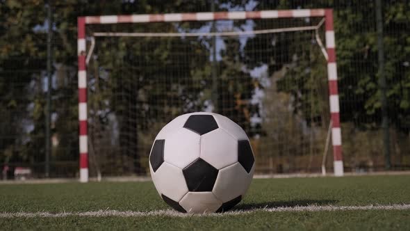 Close-up of Schoolboy Boy in Football Boots Hitting the Goal with a Soccer Ball