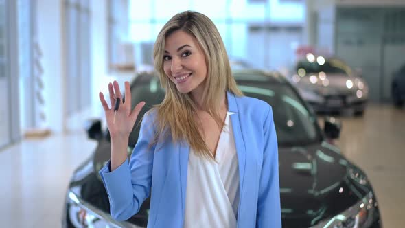 Portrait of Satisfied Caucasian Successful Woman Pointing at Car Key Smiling Looking at Camera